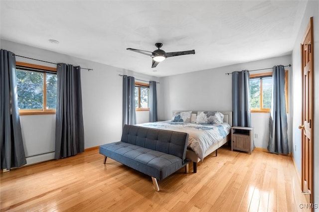 1659 Honoco Rd, Ledyard, NY 13026 - bedroom with light wood-style floors, a ceiling fan, and a baseboard heating unit