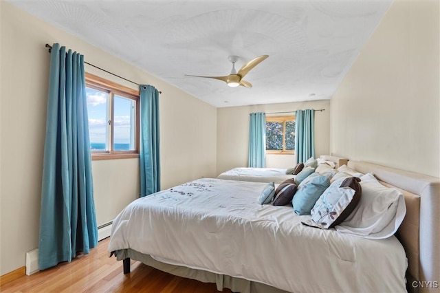 1659 Honoco Rd, Ledyard, NY 13026 - bedroom featuring light wood-type flooring, a baseboard heating unit, and ceiling fan