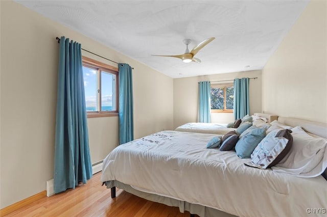 1659 Honoco Rd, Ledyard, NY 13026 - bedroom featuring light wood-type flooring, a baseboard heating unit, and ceiling fan
