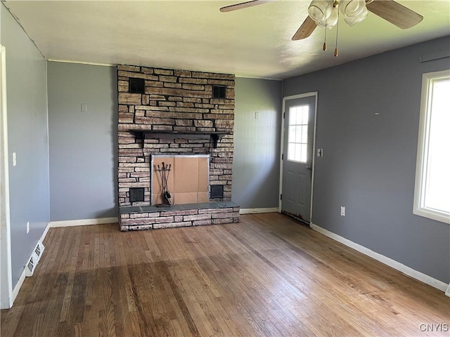 17106 State Route 3, Hounsfield, NY 13601 - unfurnished living room with ceiling fan, wood finished floors, and a stone fireplace