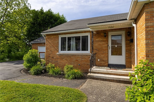 304 Simpson Rd, Irondequoit, NY 14617 - view of exterior entry with brick siding and roof with shingles