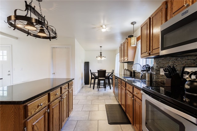 304 Simpson Rd, Irondequoit, NY 14617 - kitchen with appliances with stainless steel finishes, a chandelier, brown cabinets, backsplash, and light tile patterned floors