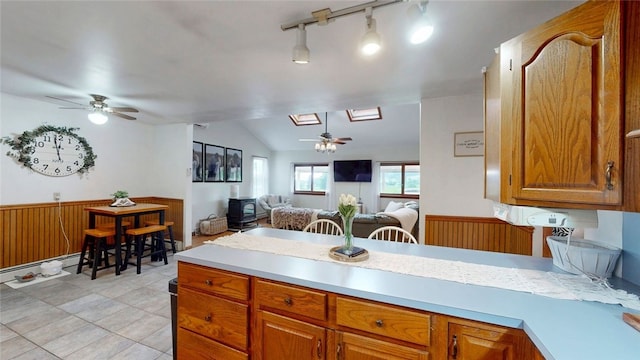 9447 County Route 75, Pulteney, NY 14418 - kitchen featuring ceiling fan, light countertops, vaulted ceiling, brown cabinets, and open floor plan