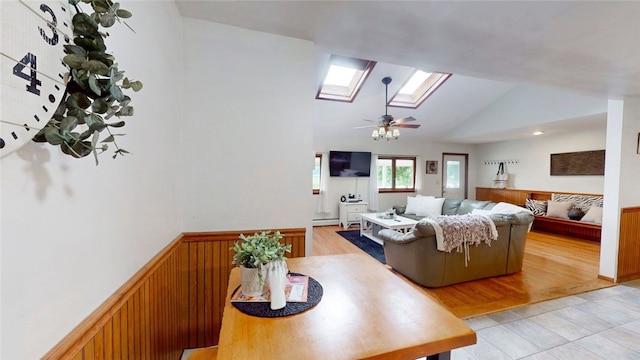 9447 County Route 75, Pulteney, NY 14418 - living room featuring a skylight, vaulted ceiling, a ceiling fan, baseboard heating, and light tile patterned floors