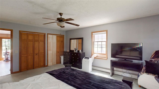9447 County Route 75, Pulteney, NY 14418 - carpeted bedroom with multiple closets, baseboard heating, ceiling fan, and a textured ceiling