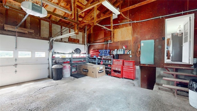 9447 County Route 75, Pulteney, NY 14418 - garage featuring a garage door opener, freestanding refrigerator, and a workshop area