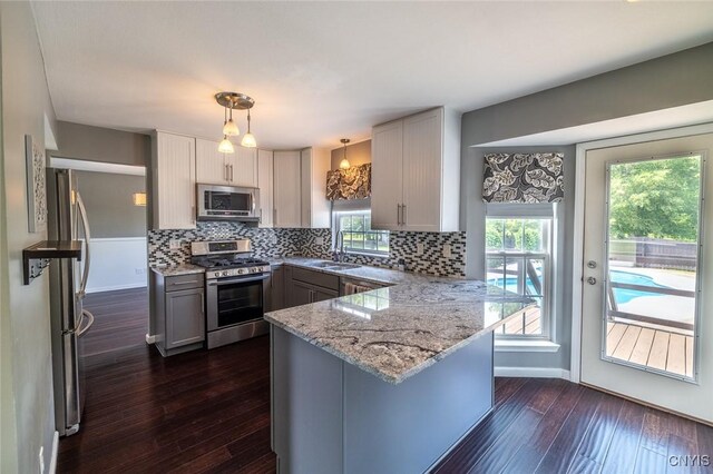 110 Clark Cir, Lenox, NY 13032 - kitchen with stainless steel appliances, a peninsula, backsplash, and dark wood-style floors