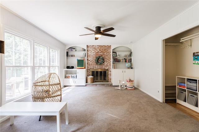 7 Chipping Rdg, Perinton, NY 14450 - living room with ceiling fan, a brick fireplace, built in shelves, carpet, and ornamental molding