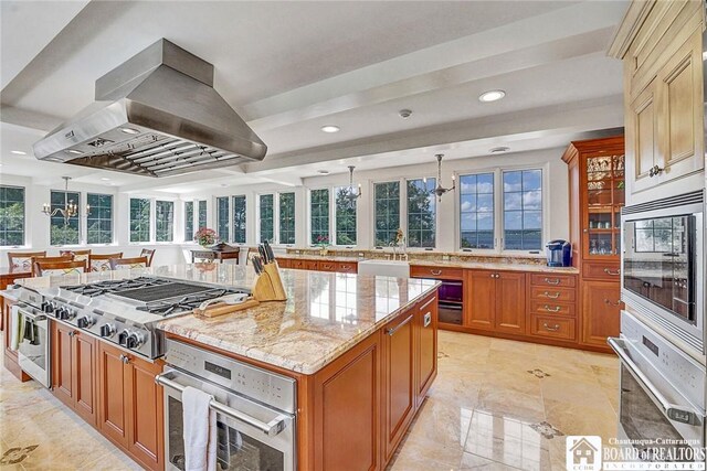 10 Elm Ln, Chautauqua, NY 14722 - kitchen with appliances with stainless steel finishes, island range hood, brown cabinets, light stone counters, and a kitchen island