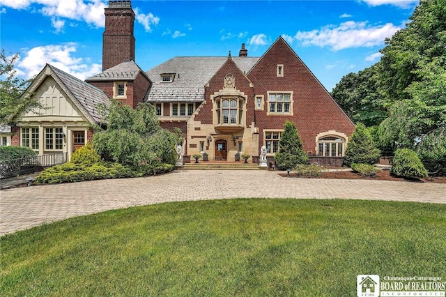 10 Elm Ln, Chautauqua, NY 14722 - tudor house with a chimney, a front yard, brick siding, and a high end roof