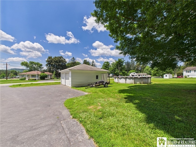 1683 Haskell Rd, Portville, NY 14760 - view of property exterior featuring an outdoor structure, a yard, a detached garage, and an outdoor pool