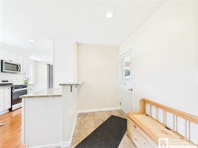 1683 Haskell Rd, Portville, NY 14760 - kitchen featuring stainless steel appliances, white cabinets, light stone countertops, a peninsula, and recessed lighting