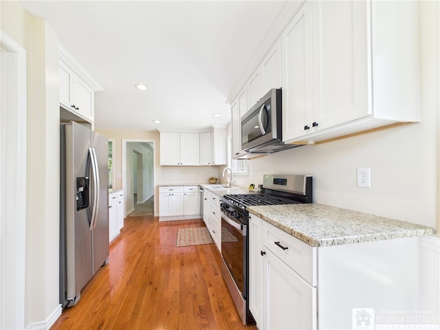 1683 Haskell Rd, Portville, NY 14760 - kitchen featuring stainless steel appliances, light wood-style floors, recessed lighting, white cabinetry, and light stone countertops