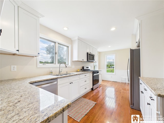 1683 Haskell Rd, Portville, NY 14760 - kitchen featuring stainless steel appliances, light wood-style flooring, white cabinets, light stone counters, and wainscoting
