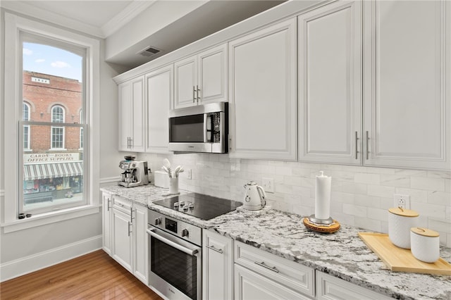 114-116 Main St Unit 114, Milo, NY 14527 - kitchen with stainless steel appliances, ornamental molding, tasteful backsplash, white cabinetry, and light wood-type flooring