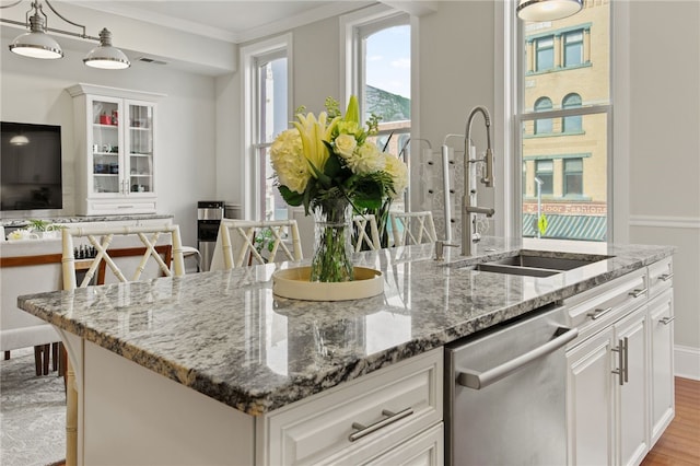 114-116 Main St Unit 114, Milo, NY 14527 - kitchen featuring stainless steel dishwasher, an island with sink, light stone counters, white cabinets, and glass insert cabinets