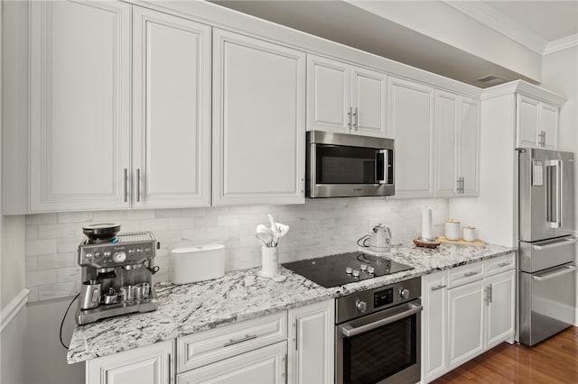 114-116 Main St Unit 114, Milo, NY 14527 - kitchen with appliances with stainless steel finishes, white cabinetry, ornamental molding, backsplash, and light stone counters