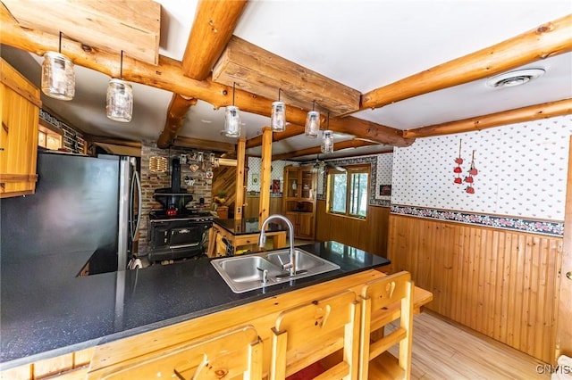 7940 Soft Maple Rd, New Bremen, NY 13327 - kitchen with light wood-style floors, wood walls, wainscoting, a wood stove, and dark countertops