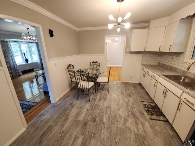 201 Jane Dr, Camillus, NY 13219 - kitchen with a chandelier, white cabinetry, light countertops, wood finished floors, and crown molding