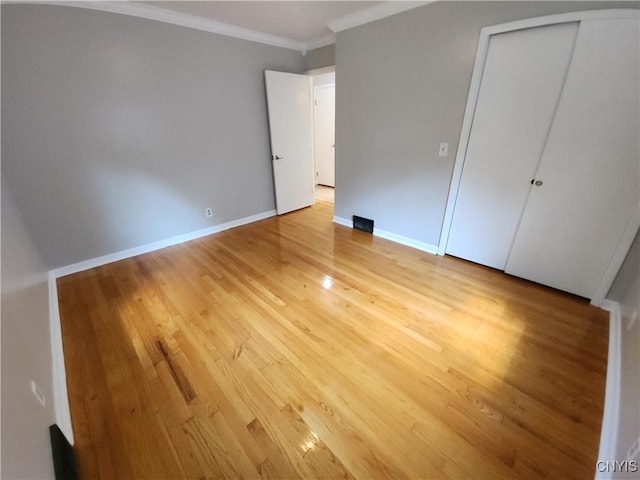 201 Jane Dr, Camillus, NY 13219 - unfurnished bedroom featuring crown molding, light wood-style floors, and a closet