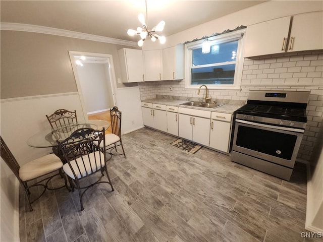 201 Jane Dr, Camillus, NY 13219 - kitchen featuring stainless steel gas range, light countertops, white cabinets, backsplash, and crown molding