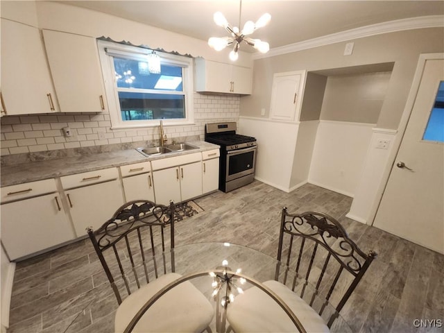 201 Jane Dr, Camillus, NY 13219 - kitchen with stainless steel gas range oven, a chandelier, white cabinetry, backsplash, and ornamental molding