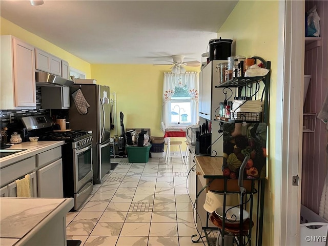 520 Seneca St, Fulton, NY 13069 - kitchen featuring appliances with stainless steel finishes, under cabinet range hood, light marble finish floors, light countertops, and ceiling fan