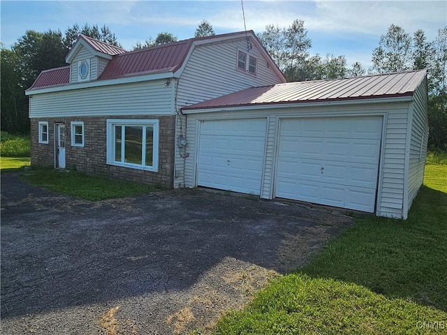 7131 State Route 8, Deerfield, NY 13502 - view of side of home with stone siding, driveway, a metal roof, a garage, and a lawn