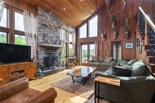 734 Post Rd, Franklin, NY 13775 - living room with high vaulted ceiling, wood ceiling, wood-type flooring, stairs, and a stone fireplace