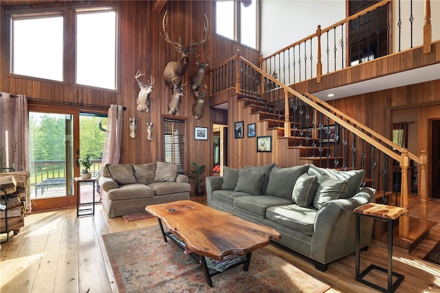 734 Post Rd, Franklin, NY 13775 - living room with wood walls, a high ceiling, stairs, and hardwood / wood-style flooring