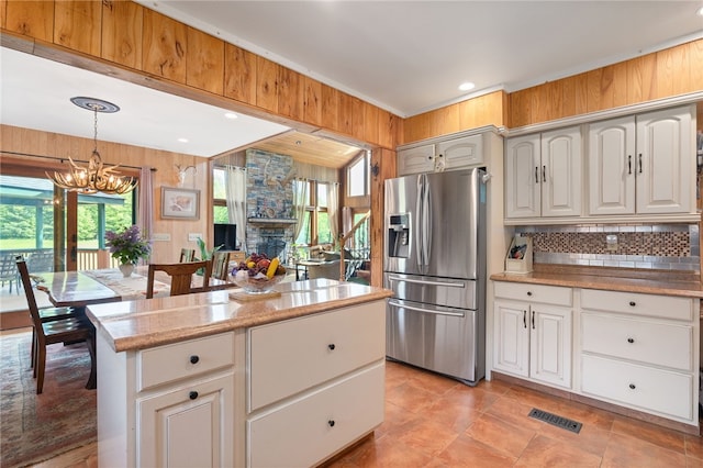 734 Post Rd, Franklin, NY 13775 - kitchen with stainless steel fridge with ice dispenser, a chandelier, wooden walls, hanging light fixtures, and backsplash