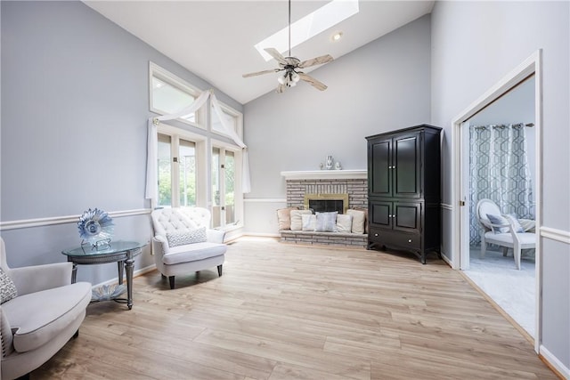 47 Edenfield Rd, Penfield, NY 14526 - living room with high vaulted ceiling, a ceiling fan, a skylight, light wood-style floors, and a brick fireplace