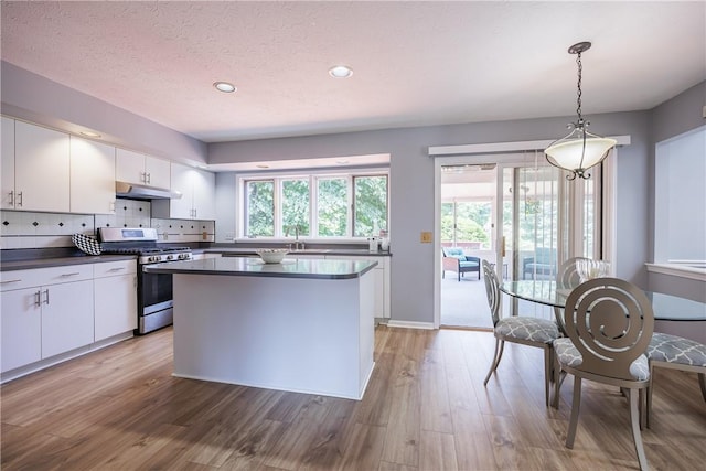 47 Edenfield Rd, Penfield, NY 14526 - kitchen featuring stainless steel gas range oven, dark countertops, under cabinet range hood, white cabinetry, and recessed lighting