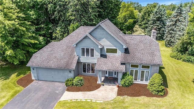 47 Edenfield Rd, Penfield, NY 14526 - view of front of house featuring asphalt driveway, a garage, a chimney, a front yard, and a shingled roof