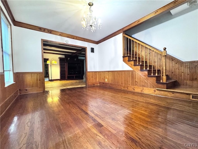 1765 W Rd, Oneida, NY 13421 - unfurnished living room featuring a chandelier, wainscoting, wood finished floors, stairs, and wooden walls