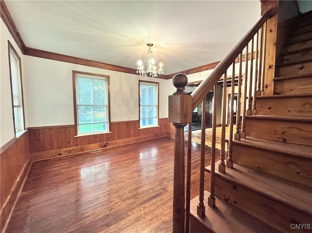 1765 W Rd, Oneida, NY 13421 - staircase featuring a wainscoted wall, a chandelier, wood finished floors, and wooden walls