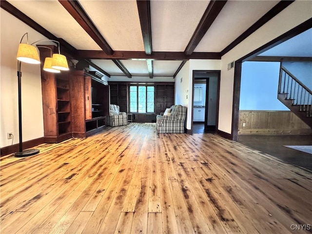 1765 W Rd, Oneida, NY 13421 - unfurnished living room with hardwood / wood-style floors, beam ceiling, and stairway
