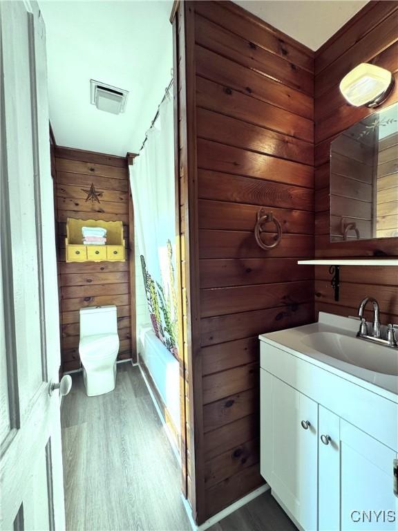 1765 W Rd, Oneida, NY 13421 - full bath featuring vanity, wood walls, wood finished floors, and shower / tub combo with curtain