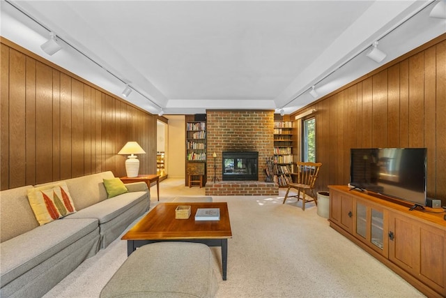 1077 Sharon Ct, Webster, NY 14580 - living area featuring rail lighting, wood walls, a brick fireplace, light carpet, and built in shelves