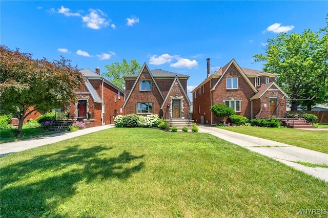 711 Colvin Blvd, Tonawanda, NY 14217 - tudor-style house featuring a front yard and brick siding