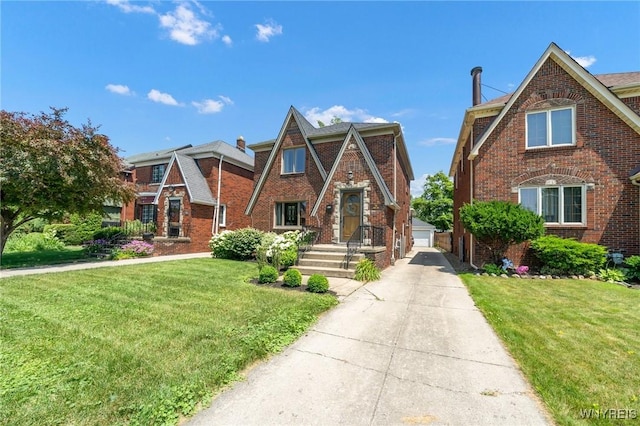 711 Colvin Blvd, Tonawanda, NY 14217 - tudor-style house with an outdoor structure, a front yard, and brick siding