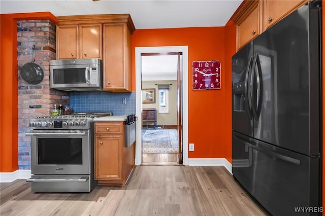 711 Colvin Blvd, Tonawanda, NY 14217 - kitchen featuring appliances with stainless steel finishes, light wood-type flooring, brown cabinets, and light countertops