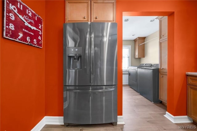 711 Colvin Blvd, Tonawanda, NY 14217 - kitchen with stainless steel fridge with ice dispenser, washer and clothes dryer, light wood-style floors, and brown cabinets