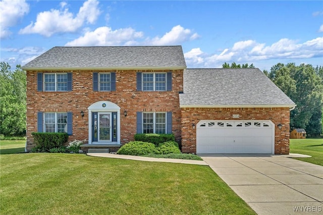 4584 Ridgeview Dr S, Pendleton, NY 14120 - colonial house featuring a front lawn, an attached garage, a shingled roof, driveway, and brick siding