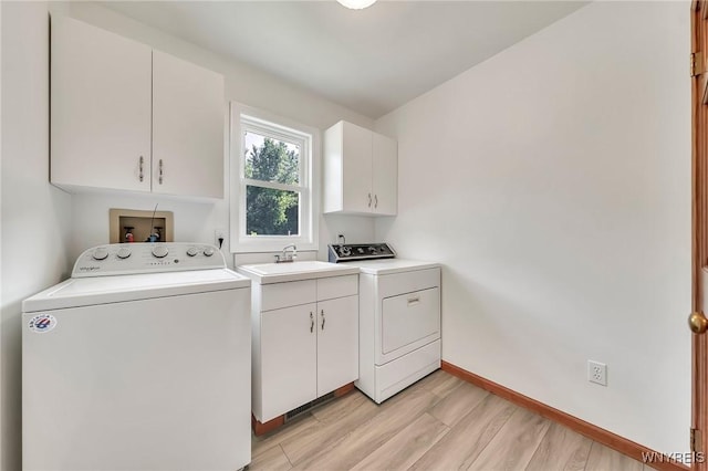4584 Ridgeview Dr S, Pendleton, NY 14120 - laundry area with cabinet space, washing machine and clothes dryer, and light wood-style floors