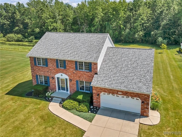 4584 Ridgeview Dr S, Pendleton, NY 14120 - colonial home with roof with shingles, an attached garage, driveway, a front lawn, and brick siding