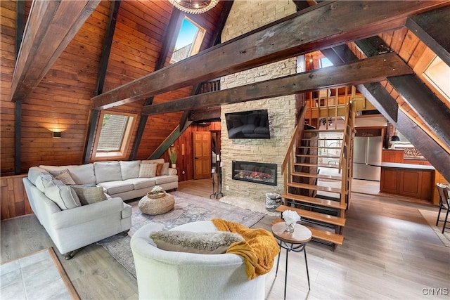 6139 Commane Rd, Lafayette, NY 13084 - living area with light wood-style floors, wood ceiling, a stone fireplace, and wooden walls