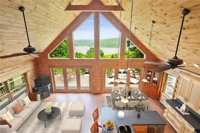 6094 State Route 21, South Bristol, NY 14512 - living area with high vaulted ceiling, a wood ceiling with exposed beams, a ceiling fan, wood walls, and wood finished floors