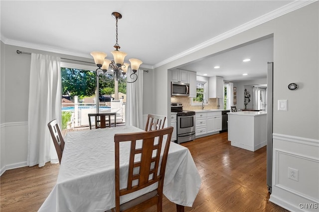 208 Single Dr, Clay, NY 13212 - dining area featuring a chandelier, healthy amount of natural light, crown molding, dark wood-type flooring, and recessed lighting