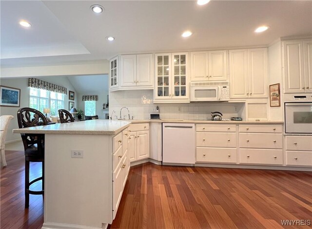 39 Wickendon Ct, Amherst, NY 14221 - kitchen with white appliances, dark wood-style flooring, recessed lighting, a kitchen bar, and white cabinetry